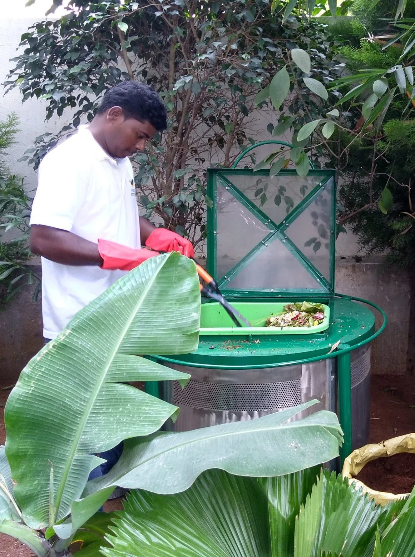 A man mixing the kitchen waste in the composter